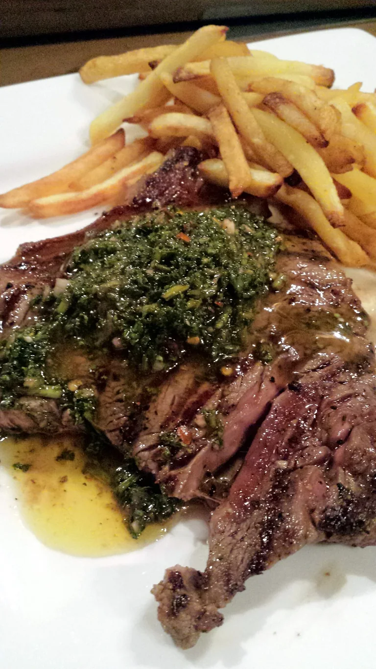 Sliced grilled steak served with an herb sauce